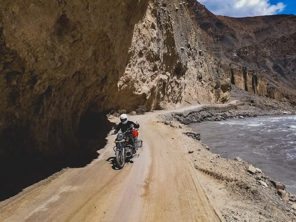 Motoristas cruzando una carretera de montaña durante una expedición