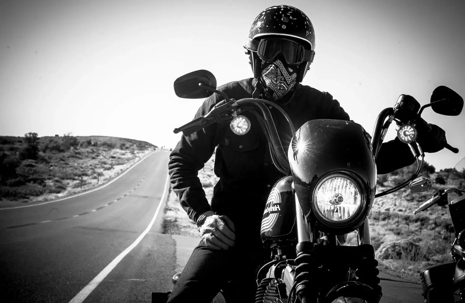 Motoristas cruzando una carretera de montaña durante una expedición